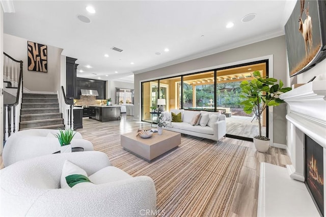 living room with light hardwood / wood-style floors and crown molding