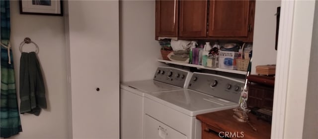 washroom with washing machine and dryer and cabinets