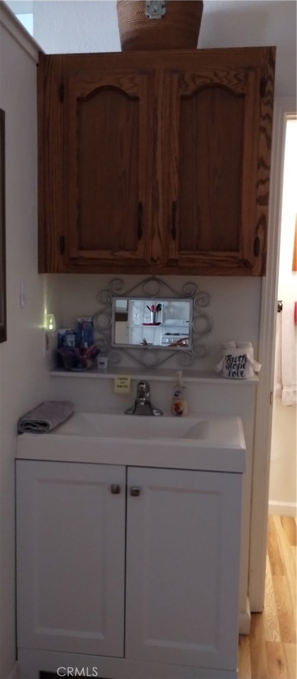 kitchen featuring white cabinetry, light hardwood / wood-style flooring, and sink