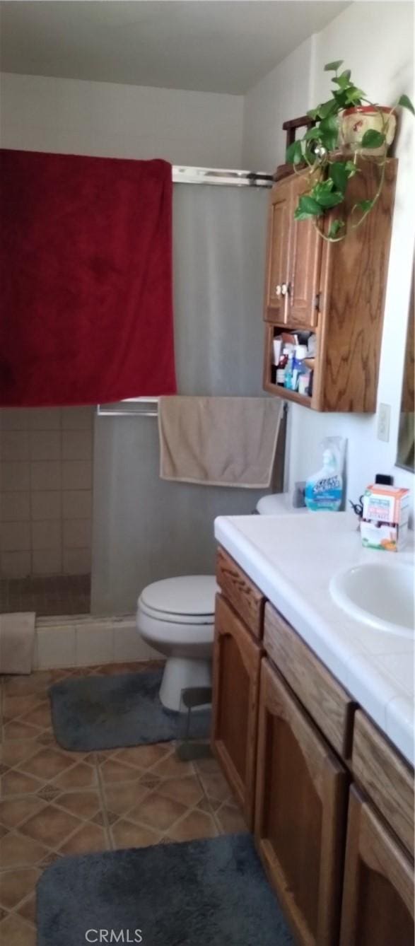 full bathroom with a walk in shower, tile patterned flooring, vanity, and toilet