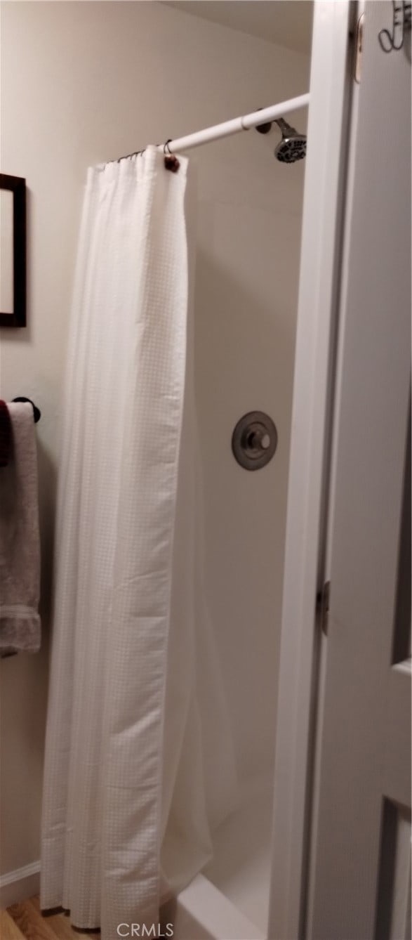 bathroom with hardwood / wood-style flooring and a shower with curtain