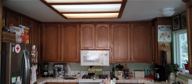 kitchen with tile counters and white appliances