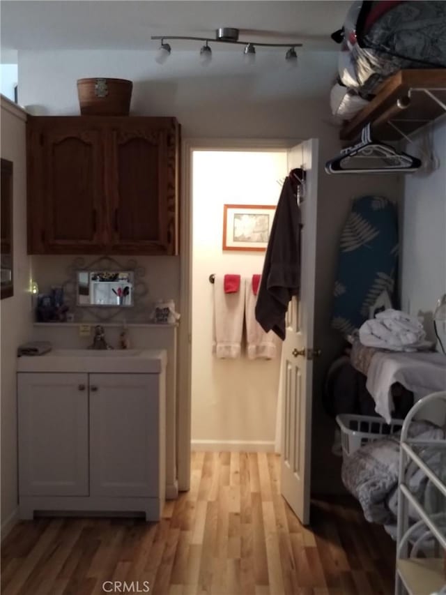 mudroom featuring light wood-type flooring and a sink