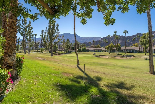 surrounding community with a yard and a mountain view