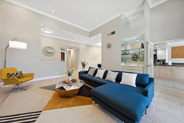 living room with ornamental molding, light tile patterned flooring, and a towering ceiling