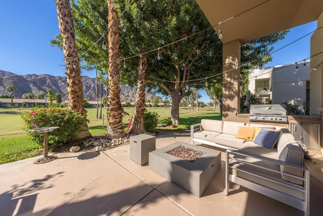 view of patio featuring a mountain view, an outdoor living space with a fire pit, and a grill