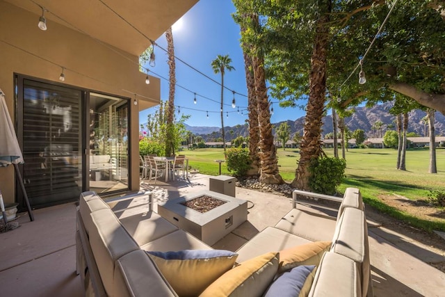 view of patio featuring a mountain view and an outdoor living space with a fire pit