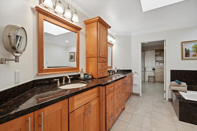 bathroom with a skylight, a tub, tile patterned floors, vanity, and ornamental molding