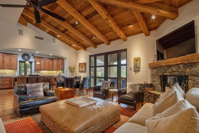 living room featuring french doors, beam ceiling, hardwood / wood-style flooring, high vaulted ceiling, and a fireplace