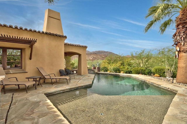 view of swimming pool with a mountain view and a patio area