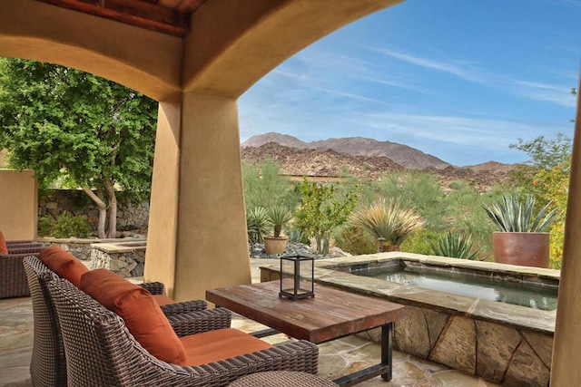 view of patio / terrace featuring a mountain view and an in ground hot tub