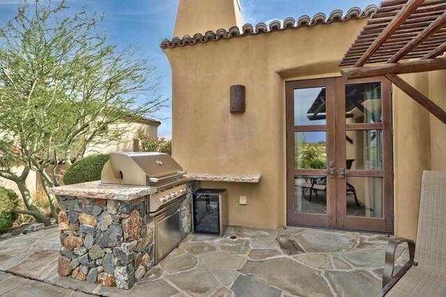 view of patio with area for grilling, exterior kitchen, and french doors