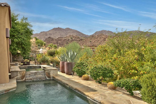 view of swimming pool with a mountain view