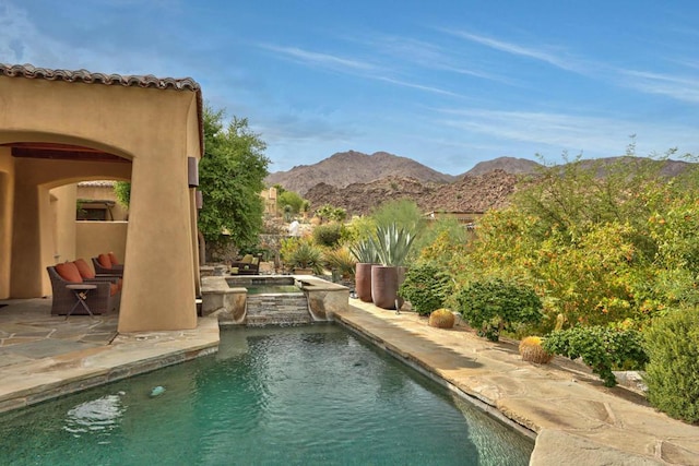 view of pool with a mountain view, a patio, and an in ground hot tub