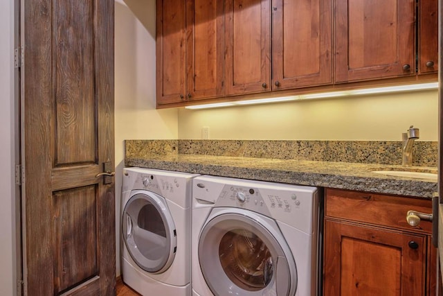 washroom with washer and dryer, cabinets, and sink