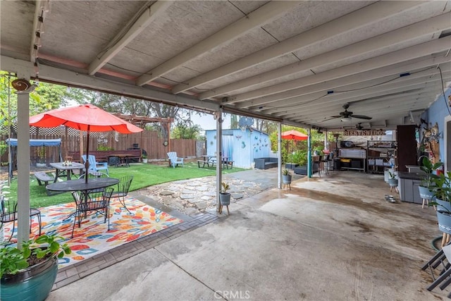 view of patio with ceiling fan and a storage shed