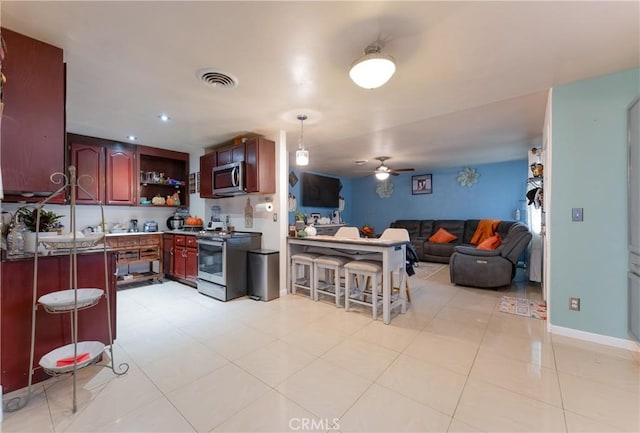 kitchen featuring a breakfast bar, electric range, kitchen peninsula, and ceiling fan