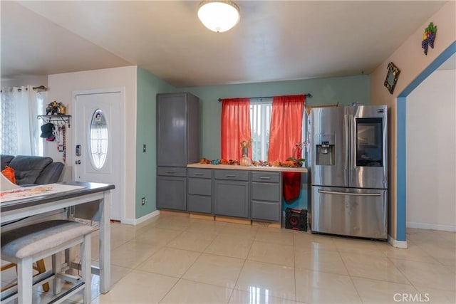 kitchen with stainless steel fridge with ice dispenser, gray cabinetry, and a healthy amount of sunlight