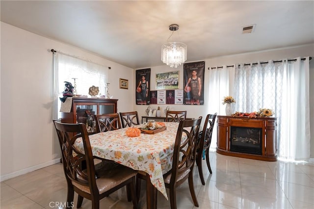 tiled dining area with an inviting chandelier