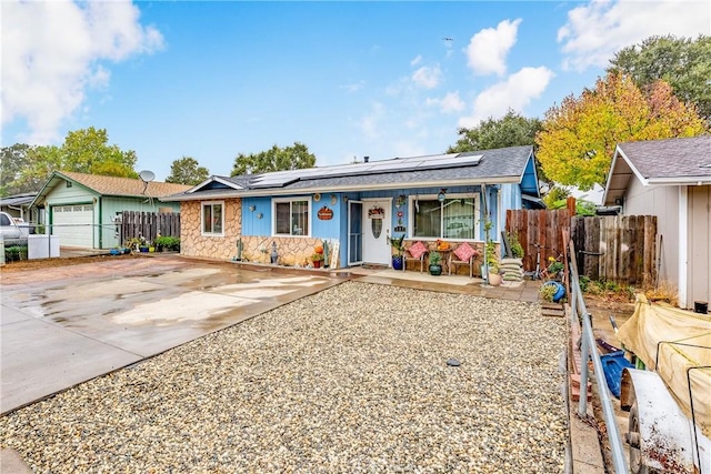 ranch-style home featuring covered porch and solar panels