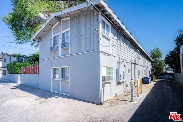 view of side of home with a wall mounted AC