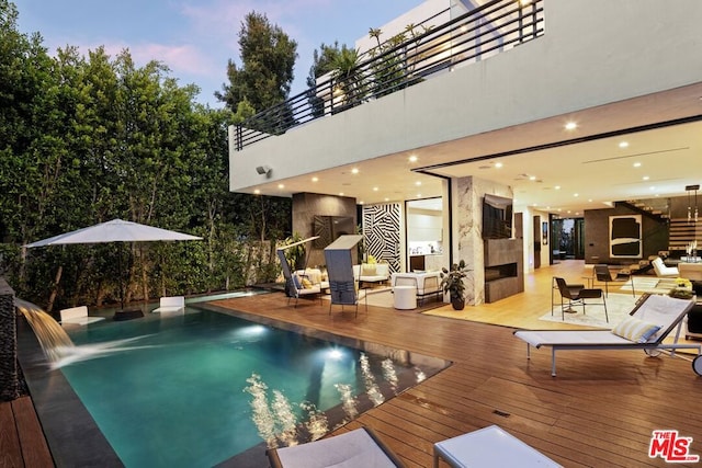 pool at dusk with a wooden deck