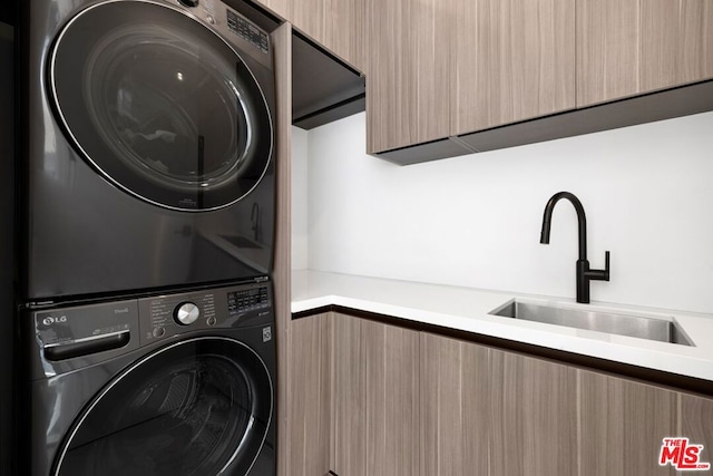 washroom featuring sink and stacked washing maching and dryer