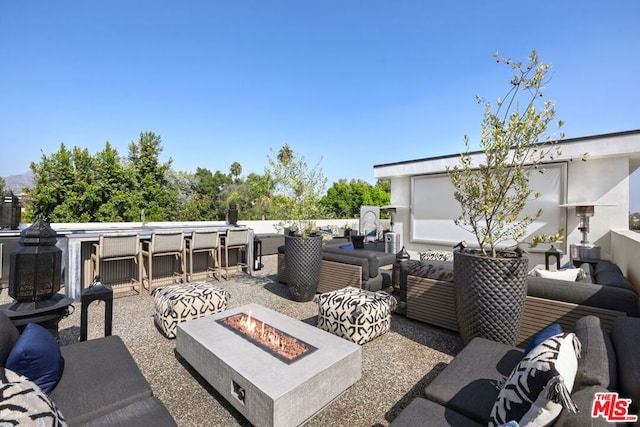 view of patio with an outdoor living space with a fire pit