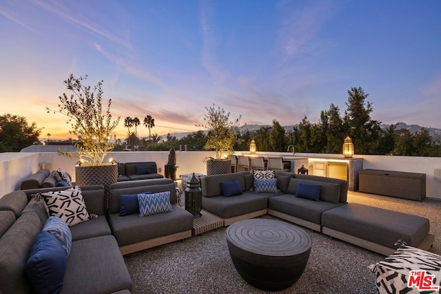 patio terrace at dusk featuring an outdoor living space