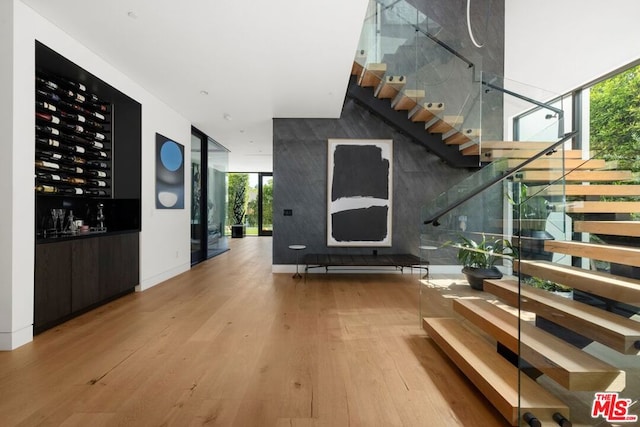 stairs with a wall of windows and hardwood / wood-style flooring