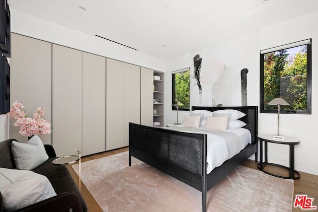 bedroom with light hardwood / wood-style flooring and multiple windows