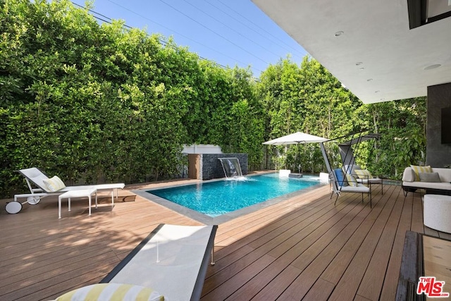 view of pool featuring pool water feature and a deck