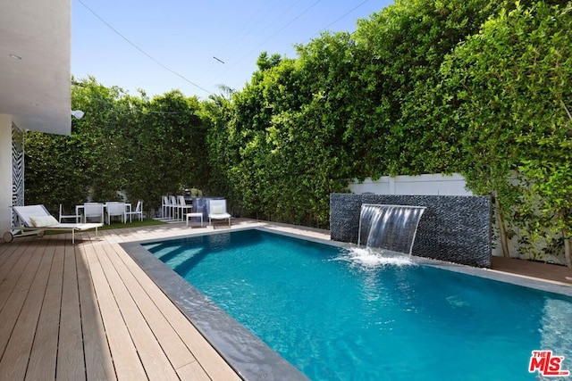 view of swimming pool featuring pool water feature and a wooden deck