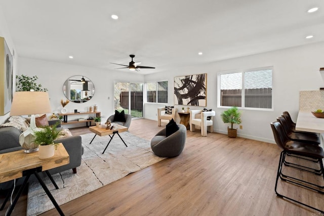 living room with light hardwood / wood-style floors and ceiling fan