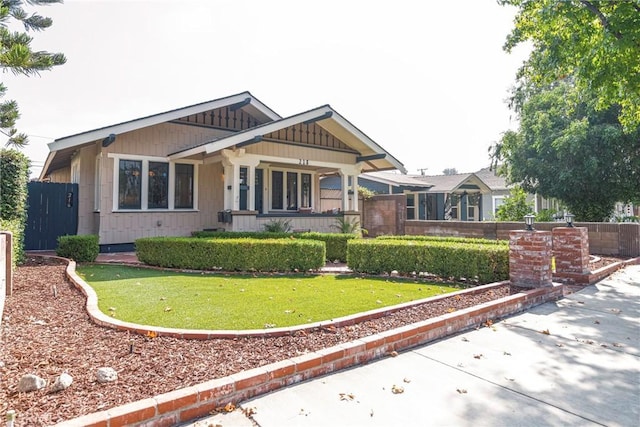 craftsman-style house featuring covered porch and a front yard