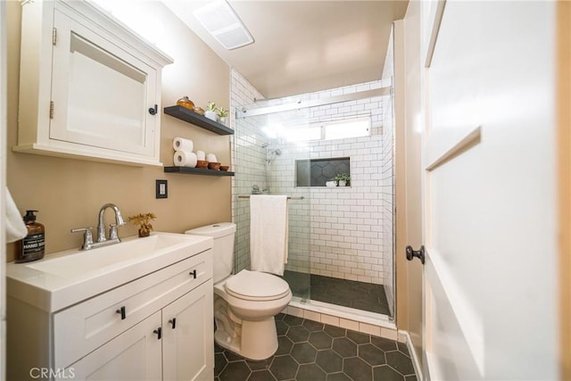 bathroom with vanity, toilet, tile patterned floors, and a shower with door