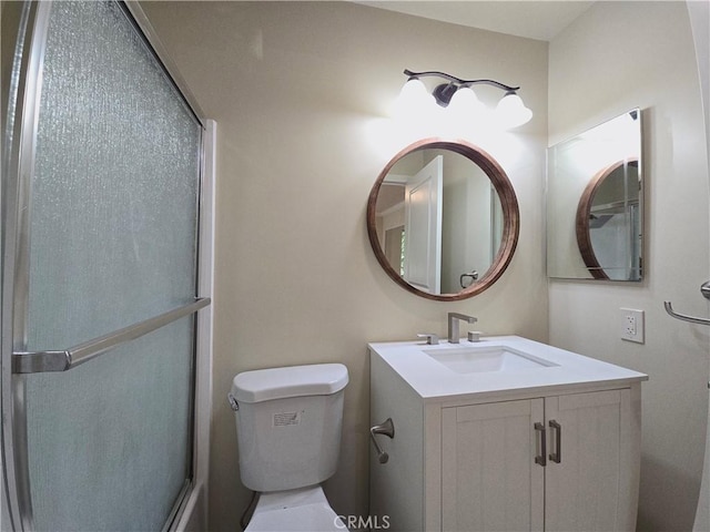 bathroom with vanity, toilet, and a shower with shower door