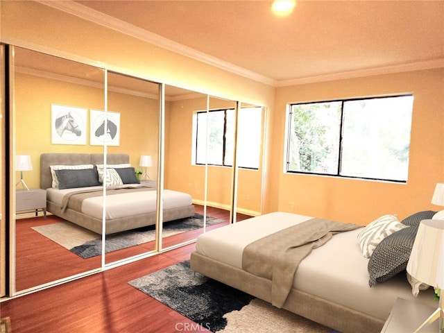 bedroom featuring hardwood / wood-style flooring, crown molding, and multiple windows