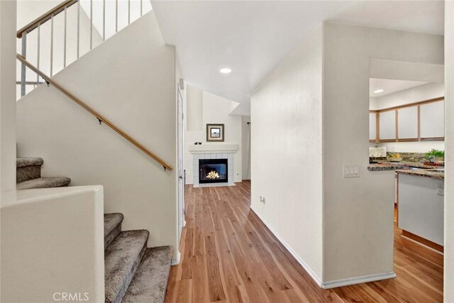 staircase featuring a fireplace and hardwood / wood-style floors