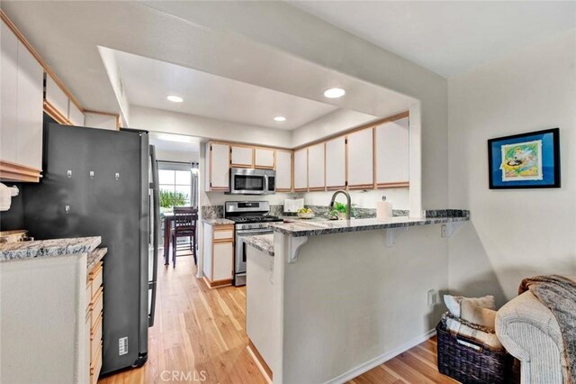 kitchen with white cabinetry, stainless steel appliances, and light hardwood / wood-style floors