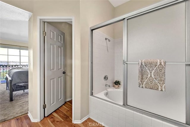 bathroom featuring combined bath / shower with glass door and wood-type flooring