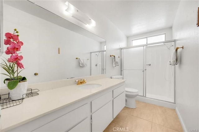 bathroom with vanity, tile patterned flooring, toilet, and walk in shower