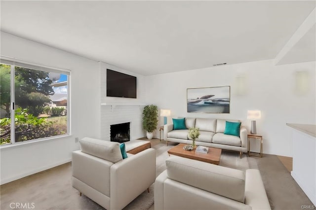 living area with visible vents, baseboards, a fireplace, and light colored carpet