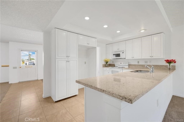 kitchen with kitchen peninsula, white cabinetry, sink, and white appliances