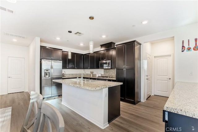 kitchen featuring stainless steel appliances, hanging light fixtures, light hardwood / wood-style floors, and sink