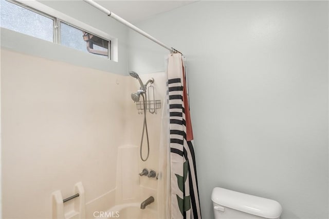 bathroom featuring shower / bath combo with shower curtain and toilet