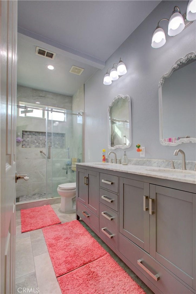 bathroom with a shower with door, vanity, and toilet