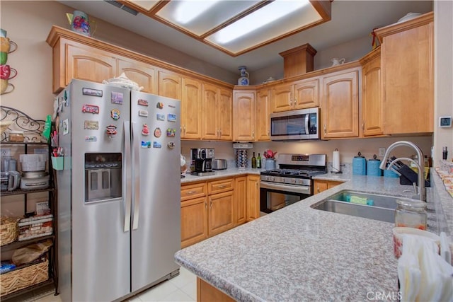 kitchen with stainless steel appliances, sink, and light brown cabinets