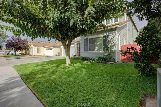 obstructed view of property with a garage and a front lawn