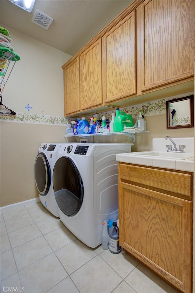 laundry room featuring independent washer and dryer, sink, cabinets, and light tile patterned floors